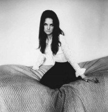 Actress Elizabeth Taylor look-alike kneeling on a bed by Diane Arbus (1960)