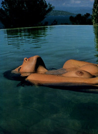 Topless Female Model Floating in Pool  by Helmut Newton (1976)
