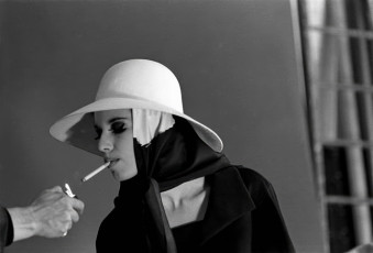 An off-camera person holds a cigarette lighter for an unidentified model, Paris by Jerry Schatzberg (1962)