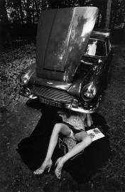 Woman under a car by Jeanloup Sieff (1964)