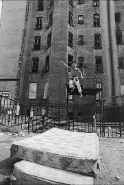 A boy jumps in the Lower East Side, New York by Allan Tannenbaum (1974)