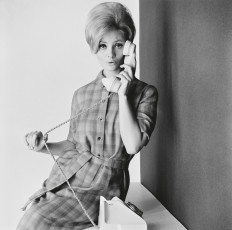 Lady on the telephone in a belted checked dress, 1960s