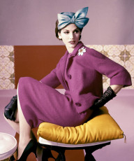 A model wears a fuscia dress suit and hat by Horst P. Horst (1961)