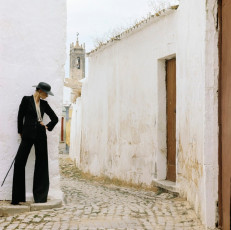 Fashion model in Loule, Portugal wearing an outfit by Saint Laurent by Norman Parkinson (1973)